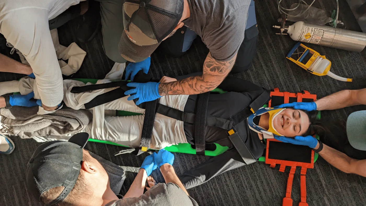 Kumari, a Delta instructor, strapped to a spine board as the patient while students practise spinal packaging
